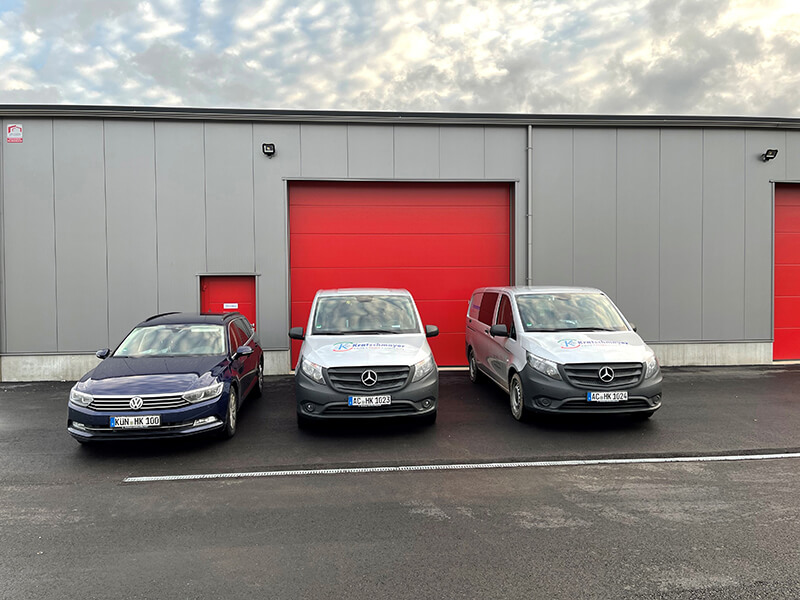 Drei Fahrzeugen stehen vor der Halle des neuen Standorts in Eschweiler