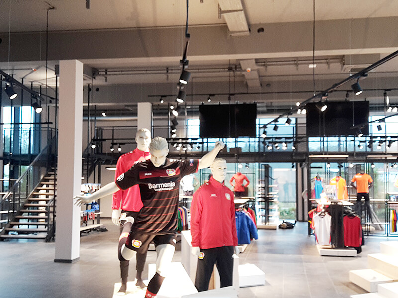 Drei Schaufensterpuppen mit Sportbekleidung in einem Showroom eines Bekleidungsherstellers
